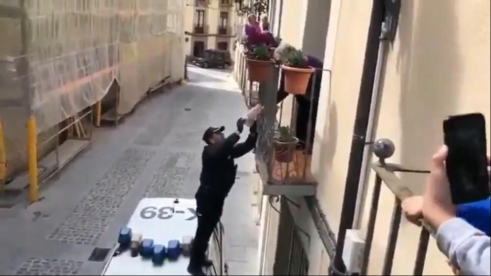 Un policía trepa hasta el balcón de una anciana para entregarle un regalo de cumpleaños